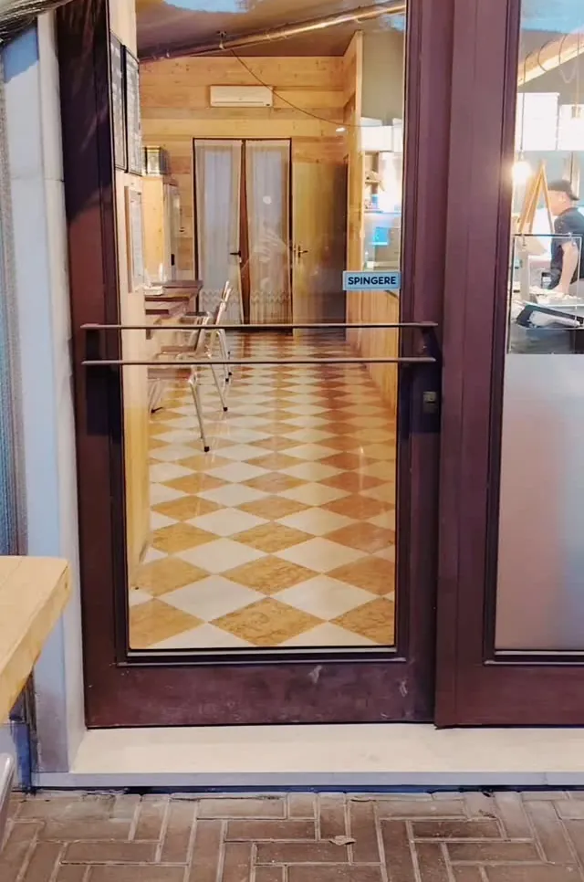 L’ingresso di Pizza Voglia, con il pavimento a scacchi color crema e terracotta